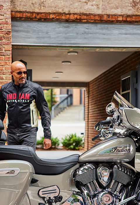 Man walking towards his 2025 Indian Roadmaster Limited touring-style motorcycle.