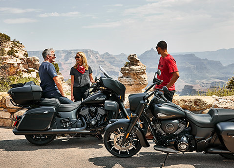3 people standing around two 2026 Indian Roadmaster Dark Horse touring motorcycles.