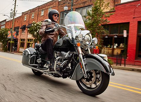Hombre conduciendo una motocicleta tipo bagger Indian Springfield 2025 por una calle de la ciudad.