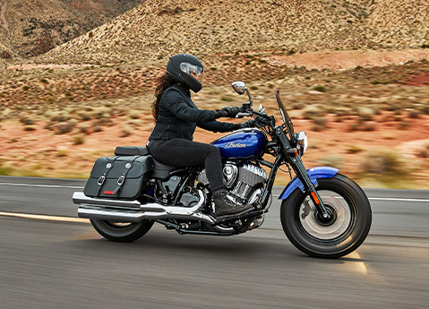Person riding a 2025 Indian Super Chief Limited bagger-style motorcycle in Spirit Blue Metallic.