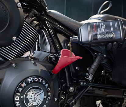 Person filling up their bike with OEM Indian Motorcycles oil.