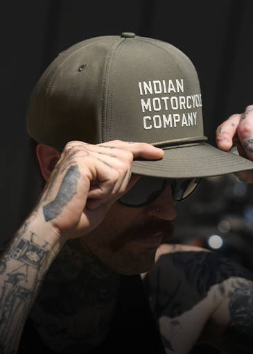 Man putting on Indian Motorcycle branded hat. 