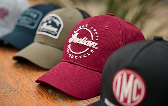Group of Indian Motorcycle hats on a table. 