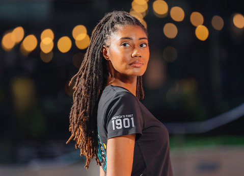 Side view of woman wearing Indian Motorcycle x RVSO collection t-shirt. 