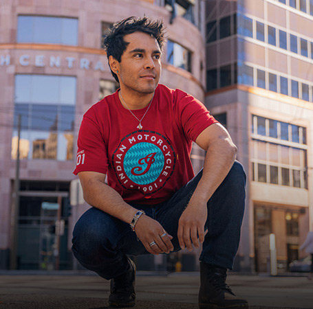 Man wearing Indian Motorcycle x RVSO printed t-shirt. 