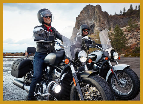 2 Indian Motorcycle Elite Status riders parked mountain-side.