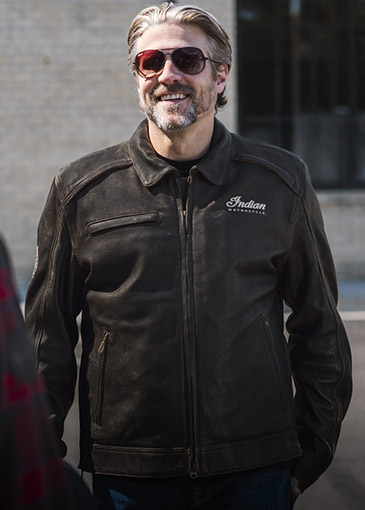 Un hombre con chaqueta de cuero Indian Motorcycle. 