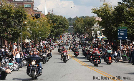 Large crowd of motorcyclists on the road at Bikes, Blues, & BBQ motorcycle rally. 