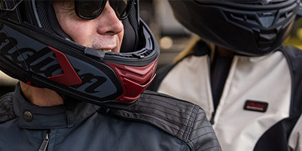Close up of people riding on a motorcycle.