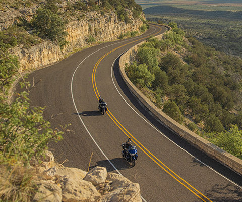 Motocicletas estilo Touring conduciendo por un sendero sinuoso.