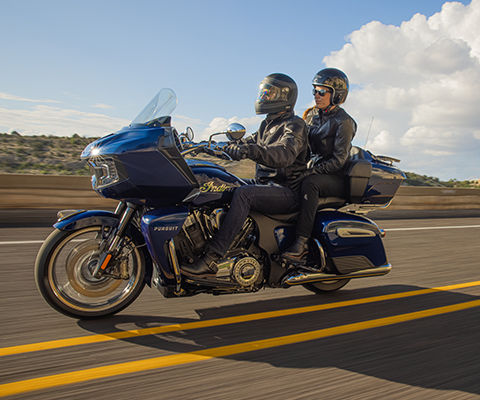 Dos personas manejando una moto Touring en un sendero.