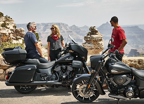 A group of friends parked with their Dark Horse blacked-out Indian motorcycles with the Grand Canyon in the background.