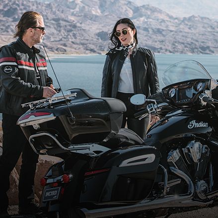 A couple preparing to ride a high-performance Indian Touring motorcycle.