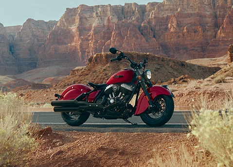 An Indian Chief vintage cruiser motorcycle parked on the highway in the desert.