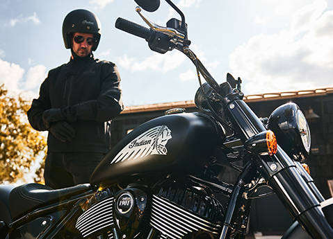 Man looking down toward his Indian Chief cruiser motorcycle before a ride.
