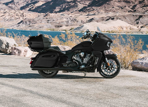 Side profile of an Indian Pursuit Limited touring motorcycle parked near a lake.