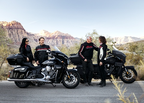 4 people standing around their Indian Roadmaster touring motorcycles.