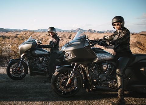 Dos conductores en sus motocicletas estilo Bagger Indian Challenger Dark Horse de 2026.