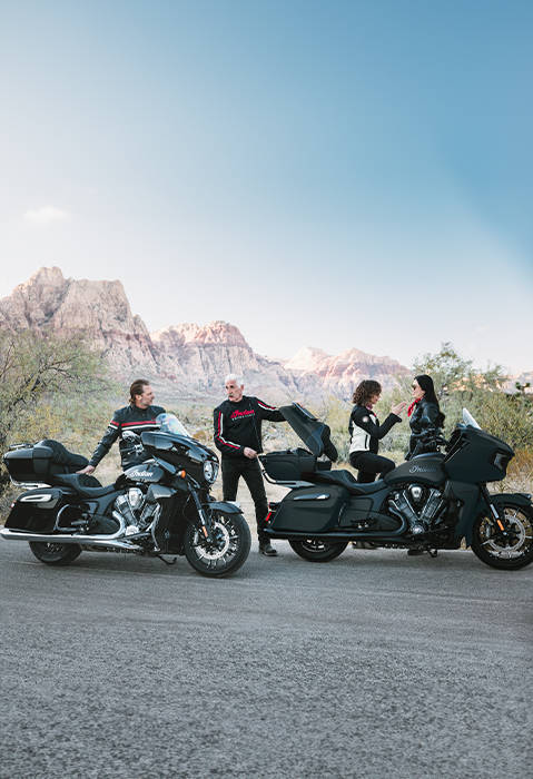 4 people gearing up and preparing to ride their 2026 Indian Pursuit touring motorcycles.
