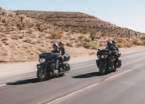 2 couples riding their 2-up 2026 Indian Pursuit touring motorcycle down the highway.