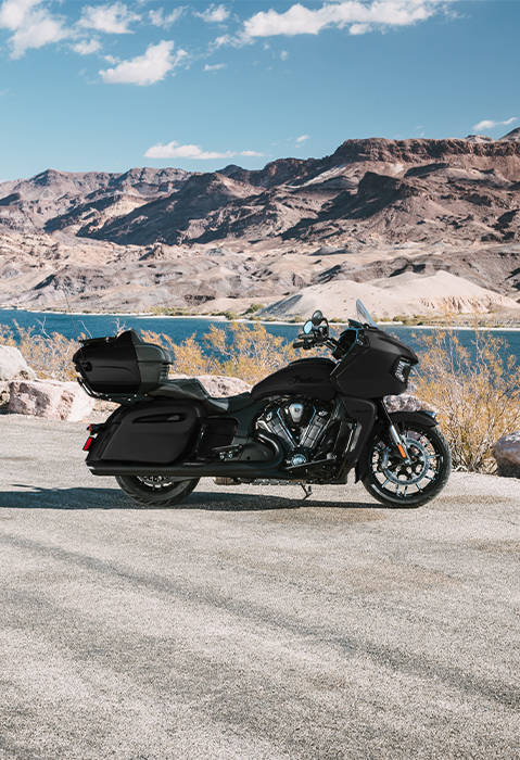 Side profile of a 2-passenger 2026 Indian Pursuit Dark Horse touring motorcycle in the black smoke colorway. 