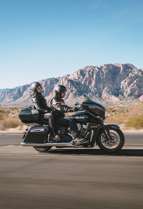 Side profile of a couple enjoying a highway cruise on their 2026 Indian Roadmaster PowerPlus Limited touring motorcycle.