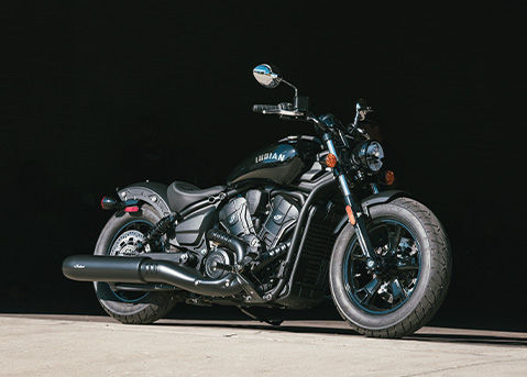 A 2026 Indian Scout Sixty Bobber cruiser motorcycle parked in a garage.