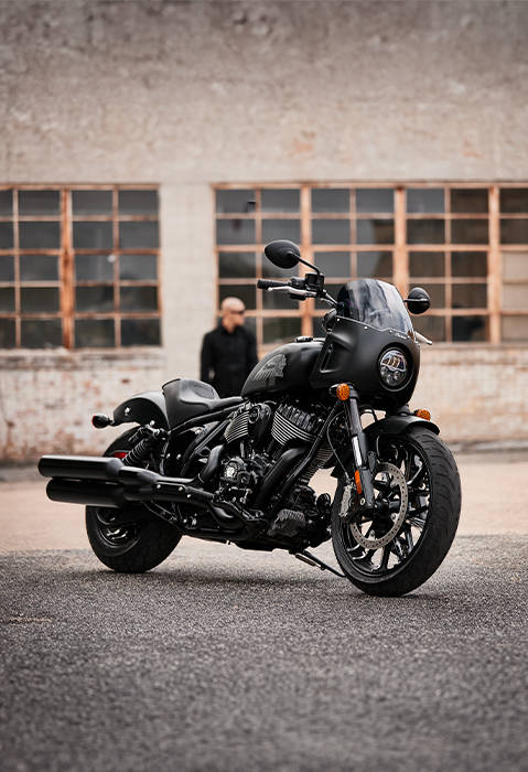 A man standing behind a 2026 Indian Sport Chief motorcycle.