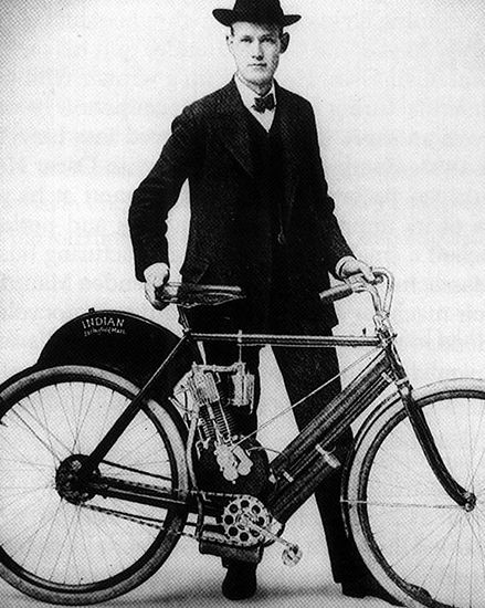 Indian Motorcycle founder George M. Hendee posing next to early Indian model. 