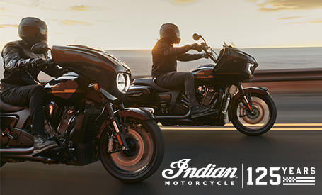 Two Indian Motorcycles cruising side-by-side at sunset, featuring the 125th Anniversary logo.