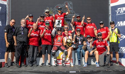 Indian Motorcycle Racing team gathers around a rider holding the 2026 King of the Baggers championship trophy at COTA.