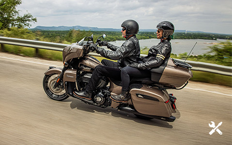 Man and woman riding and Indian Motorcycle on a road