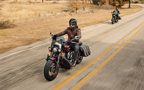 a couple of Indian Motorcycles going on a road