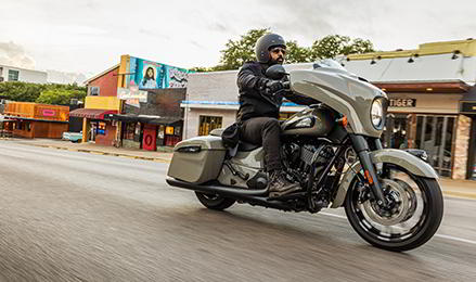 A biker using his Indian Motorcycle on the city.