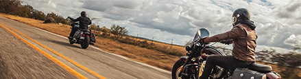 Two riders on Indian Motorcycles riding in a highway