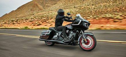 Two bikers on a red and white Bagger motorcycle. 