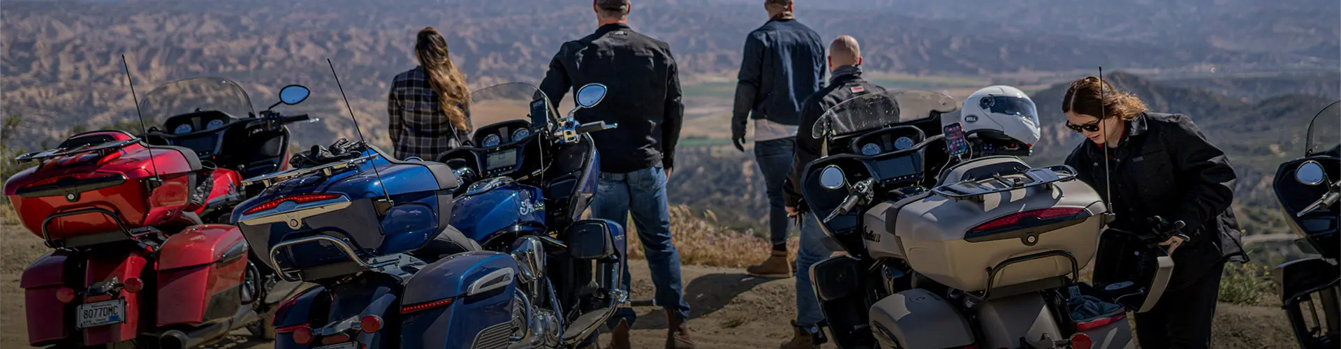 Group of Indian Motorcycle riders parked near scenic overlook.
