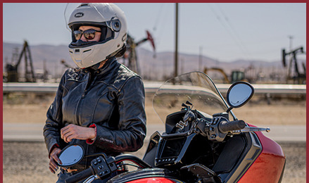 Rider leaning on her Indian Motorcycle.