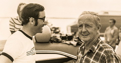 A man speaks to Burt Munro (right), a world-famous Indian Motorcycle racer in the 40s and 50s