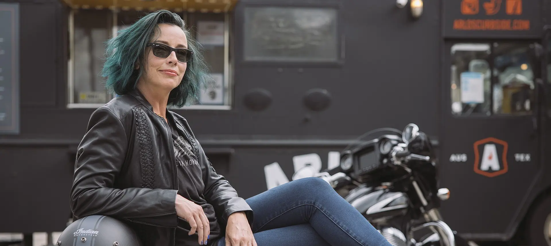 Femme assise devant une moto Indian Motorcycle