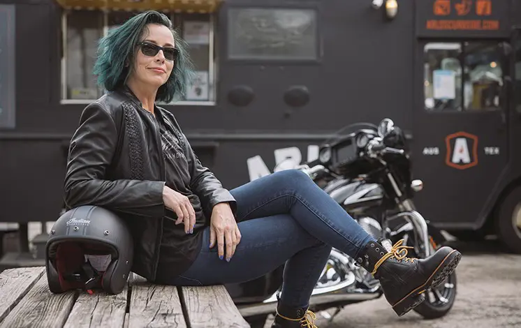 Femme assise devant une moto Indian Motorcycle