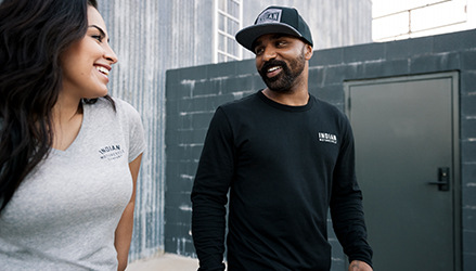 a man and a woman chatting, they wear INDIAN motorcycle apparel clothing