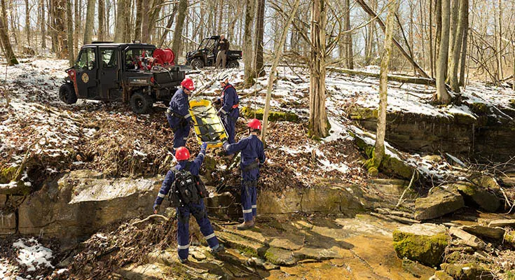 rescue crew using a skid from the cargo box of their polaris ranger