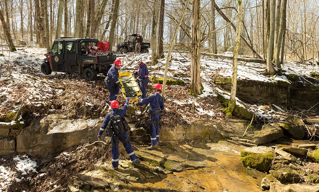 rescue crew using a skid from the cargo box of their polaris ranger