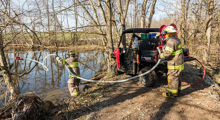 fire crew throwing water pump into pond
