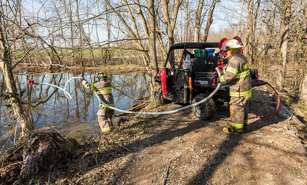 fire crew throwing water pump into pond