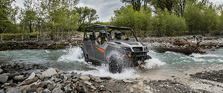 General 1000 vehicle crossing a river in the woods