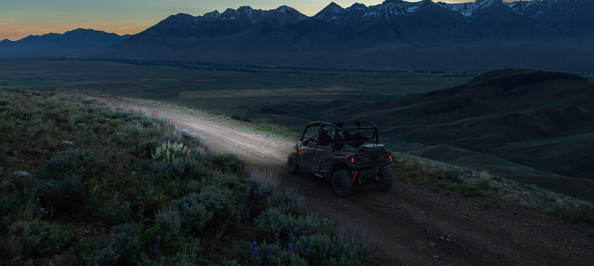 General 1000 riding in he night through a trail close to mountains