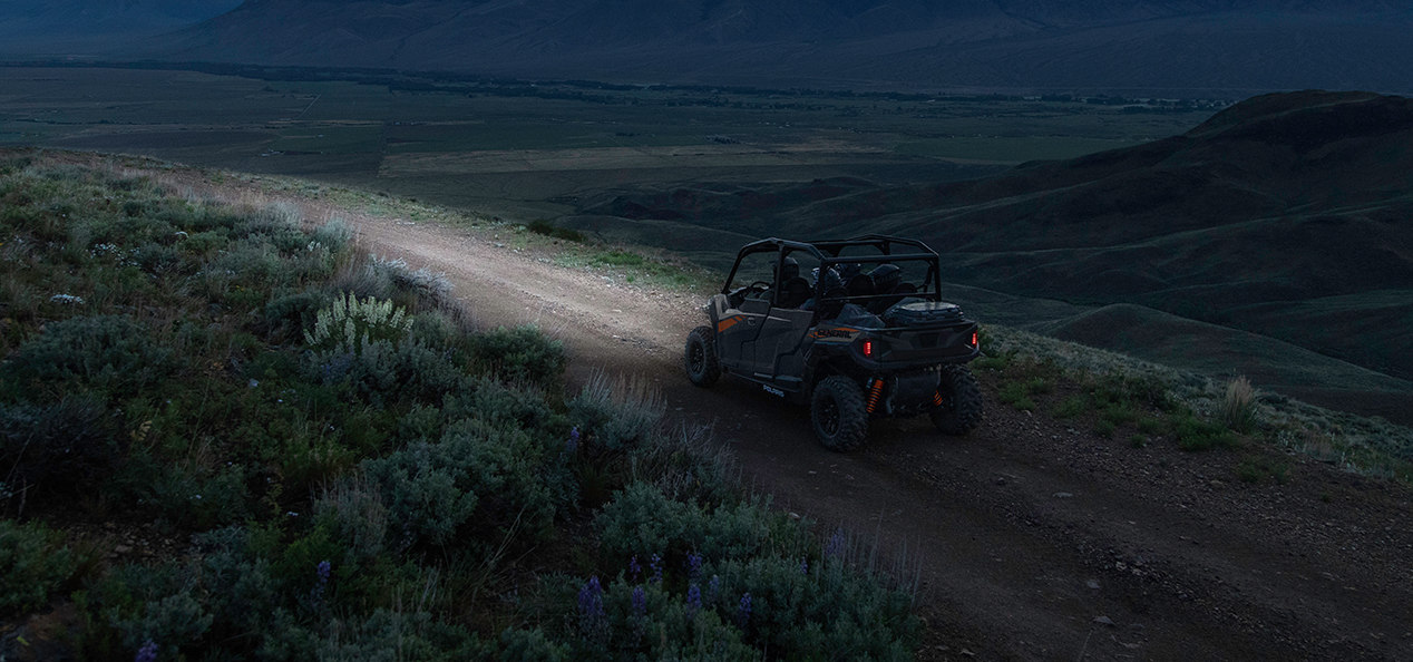 General 1000 riding in he night through a trail close to mountains