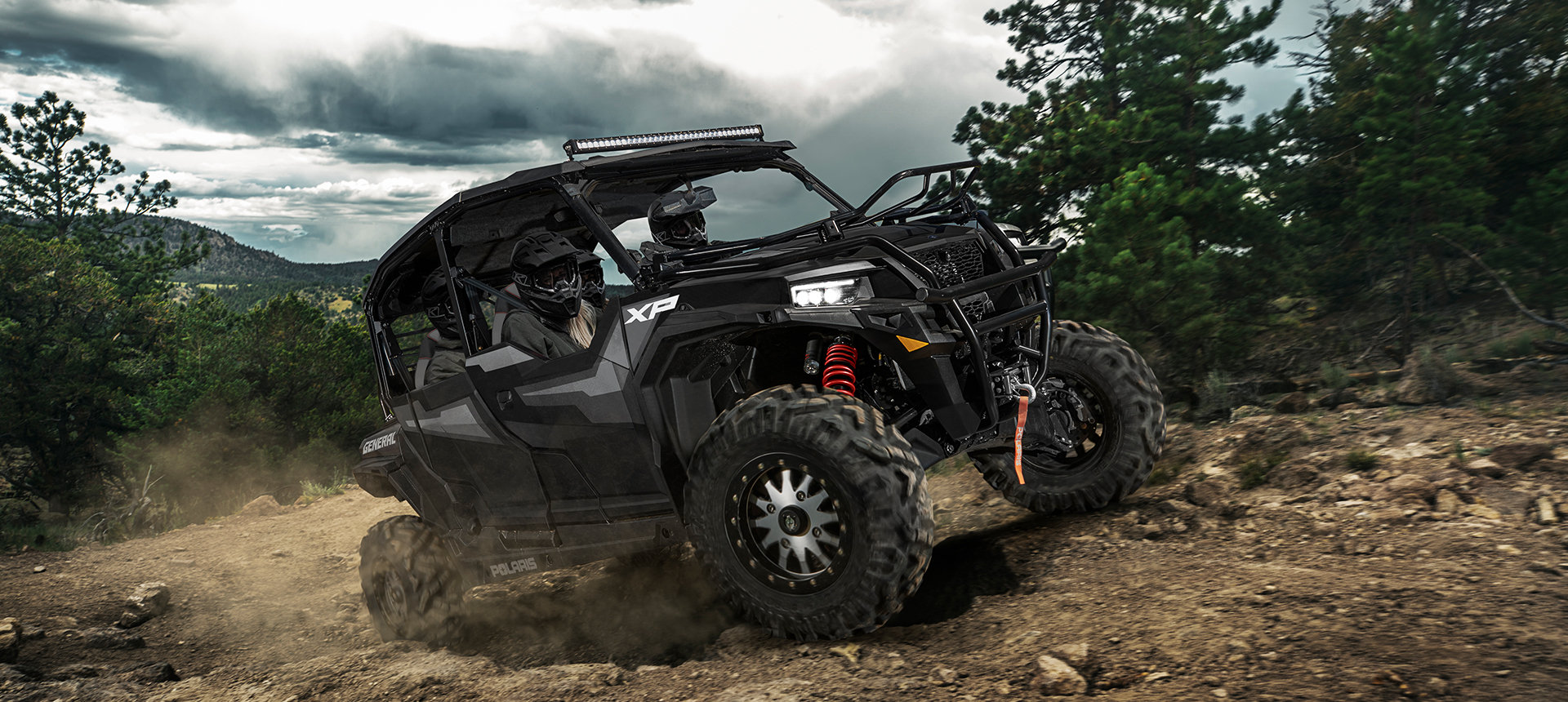 General XP 1000 vehicle riding uphill on a trail in the woods